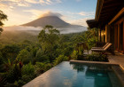 A private rainforest villa with a plunge pool, tropical plants, misty Arenal Volcano in the background, and warm sunrise light over Costa Rica